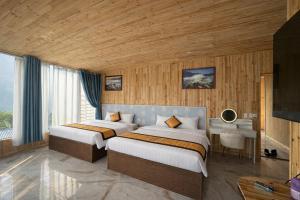 a hotel room with two beds and a television at Sapa May Ecolodge in Sapa