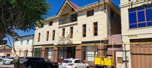 a building with cars parked in front of it at Safo Hotel Turkestan in Türkistan +21 photos