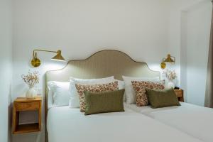 a bedroom with two beds with white sheets and pillows at Hotel Boutique Petit París in Port de Pollensa +45 photos