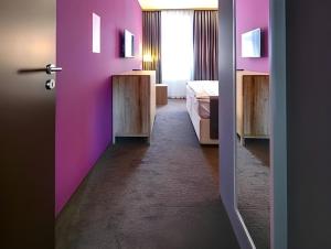 a room with a pink door with a bed and a window at Hotel Restaurant Darwin in Prague