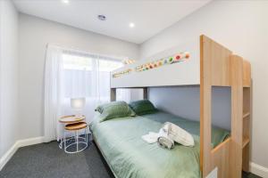 a bedroom with a bunk bed with a ladder at Wilson's Beach Beauty in Inverloch