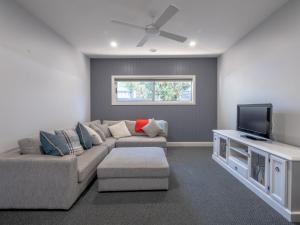 a living room with a couch and a flat screen tv at Wilson's Beach Beauty in Inverloch
