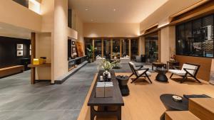 a lobby of a building with tables and chairs at Wuye WOO YEAH Tangchi Hotel in Emeishan City