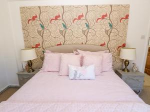 a bedroom with a pink bed with two lamps at The Museum in Alston