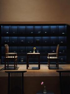 a dining room with two tables and two chairs at Wuye WOO YEAH Tangchi Hotel in Emeishan City