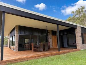 a house with a large deck with glass doors at Silk & Oak in Darlington