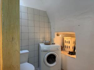 a bathroom with a toilet and a washing machine at Patrick's Traditional Home in Pyrgi +70 photos
