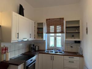 a kitchen with white cabinets and a sink and a window at Patrick's Traditional Home in Pyrgi