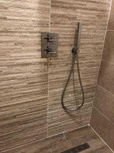 a shower with a hose in a bathroom with tiles at Moulin de Carrière, dans un parc de 2 hectares à Uzès in Uzès +30 photos