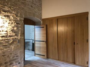 a room with a wooden door and a stone wall at Moulin de Carrière, dans un parc de 2 hectares à Uzès in Uzès
