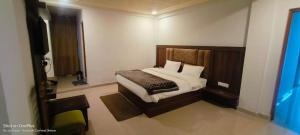 a bedroom with a bed and a television in it at Shree Kuber Regency in Badrinath