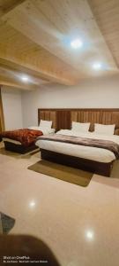 a bedroom with two beds in a room at Shree Kuber Regency in Badrinath