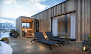 two chairs on a deck with a view of the mountains at Wieshof Wilder Kaiser by ALPS RESORTS in Söll