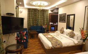 a hotel room with a bed and a flat screen tv at The Hoften Al Shaykh Resorts, Srinagar in Srinagar