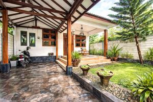 a home with a covered patio with a scooter at Ghanaya Guesthouse in Ngaglik