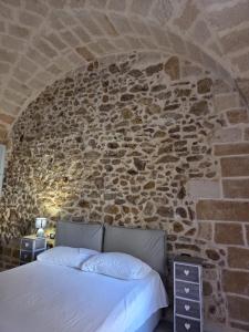 a bedroom with a stone wall with a bed at Casa vacanze G&G in Brindisi +3 photos