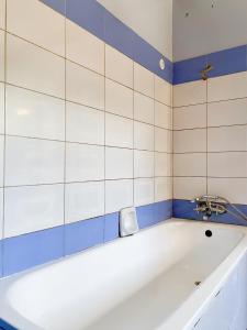 a bath tub in a bathroom with blue and white tiles at Royal Lake View Gardens in Kampala +69 photos