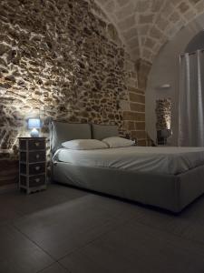a bedroom with a large bed in a brick wall at Casa vacanze G&G in Brindisi