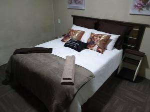 a bed with pictures of two women on the pillows at Palmnut Lodge in Durban