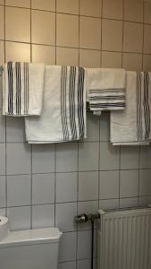 a bathroom with white towels hanging on a wall at Studio Ohlendorf 3 Min zur A7 mit Parkplatz in Seevetal +12 photos