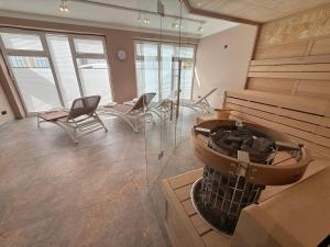 a large room with a fireplace and chairs in it at Villa Am Steinbach in Sassnitz