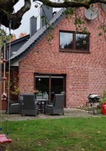 a brick house with chairs and a table in front of it at Studio Ohlendorf 3 Min zur A7 mit Parkplatz in Seevetal