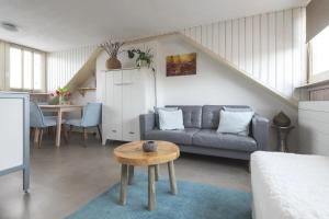 a living room with a couch and a table at Appartement Zuid 5 strand op 2 minuten lopen in Zandvoort