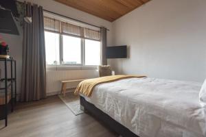 a bedroom with a large bed and a window at Appartement Zuid 5 strand op 2 minuten lopen in Zandvoort