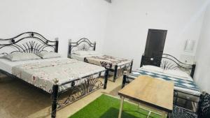 a room with two beds and a table at Mysore rooms- sgh in Mysore