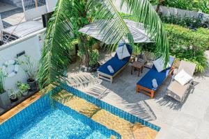 an overhead view of a pool with chairs and umbrellas at Happy Eight Resort in Nai Harn Beach