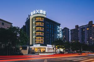 a building with lights on in a city at night at 亚轻x酒店上海同济医院新村路地铁站店 in Shanghai