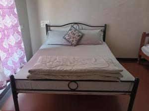 a bed with pillows on it in a bedroom at Coorg rest house in Madikeri