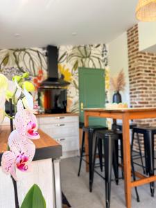 a kitchen with a table and stools in a room at Au bord de l'étang in Saint-Aubin