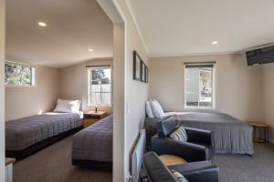 a bedroom with a bed and a couch and a bed and a chair at Wedderburn Cottages in Wedderburn