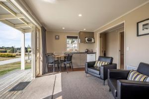 a living room with a table and chairs and a kitchen at Wedderburn Cottages in Wedderburn