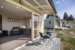 a patio with a bed and a table and chairs at Wedderburn Cottages in Wedderburn