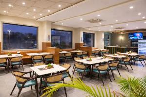 a dining room with tables and chairs in a restaurant at OPO Premier Marvel in Jaipur