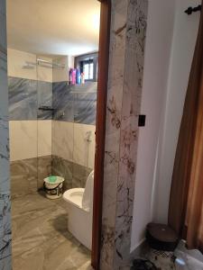 a bathroom with a toilet and a glass shower at RiverBank Gardens, Mananthavady, Wayanad in Mananthavady +73 photos