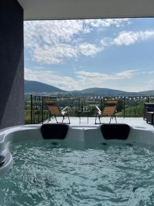 a hot tub with chairs and a patio with a view at Kosmaj Sunrise in Rogača