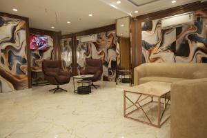 a living room with a couch and chairs and paintings at Vardaan Residency Hotel in Gorakhpur