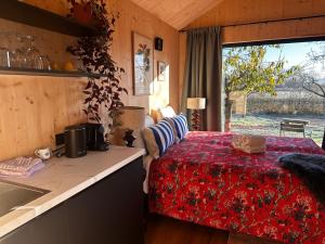 a bedroom with a bed and a kitchen with a sink at De Buitenkamer in Rijssen