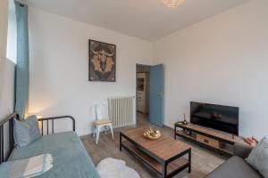 a living room with a couch and a tv at Le Sostranien - Jardin - Wifi in La Souterraine