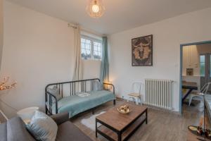 a living room with a couch and a table at Le Sostranien - Jardin - Wifi in La Souterraine +5 photos