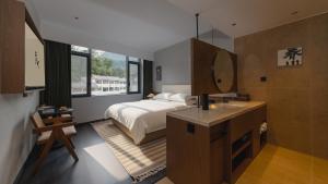 a bedroom with a bed and a sink and a mirror at Wuye WOO YEAH Tangchi Hotel in Emeishan City +113 photos