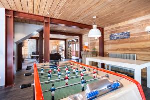 a ping pong table in a living room with wood walls at Huttopia Bourg St Maurice in Bourg-Saint-Maurice