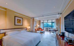 a bedroom with a large bed and a living room at Hangzhou Rose Garden Resort & Spa in Hangzhou +79 photos