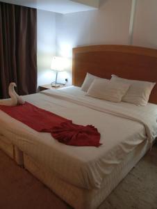 a bedroom with a bed with a red dress on it at Room Al-Malaz in Riyadh