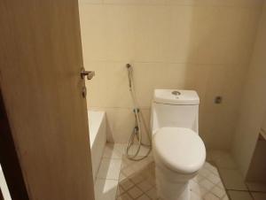 a bathroom with a white toilet and a bath tub at Room Al-Malaz in Riyadh