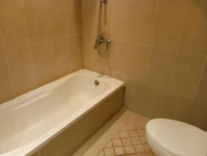 a bathroom with a white tub and a toilet at Room Al-Malaz in Riyadh