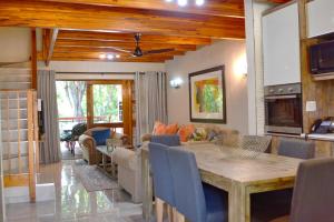 a living room with a table and a dining room at INYAMATANE LUXURY LODGES at Kruger Park Lodge in Hazyview